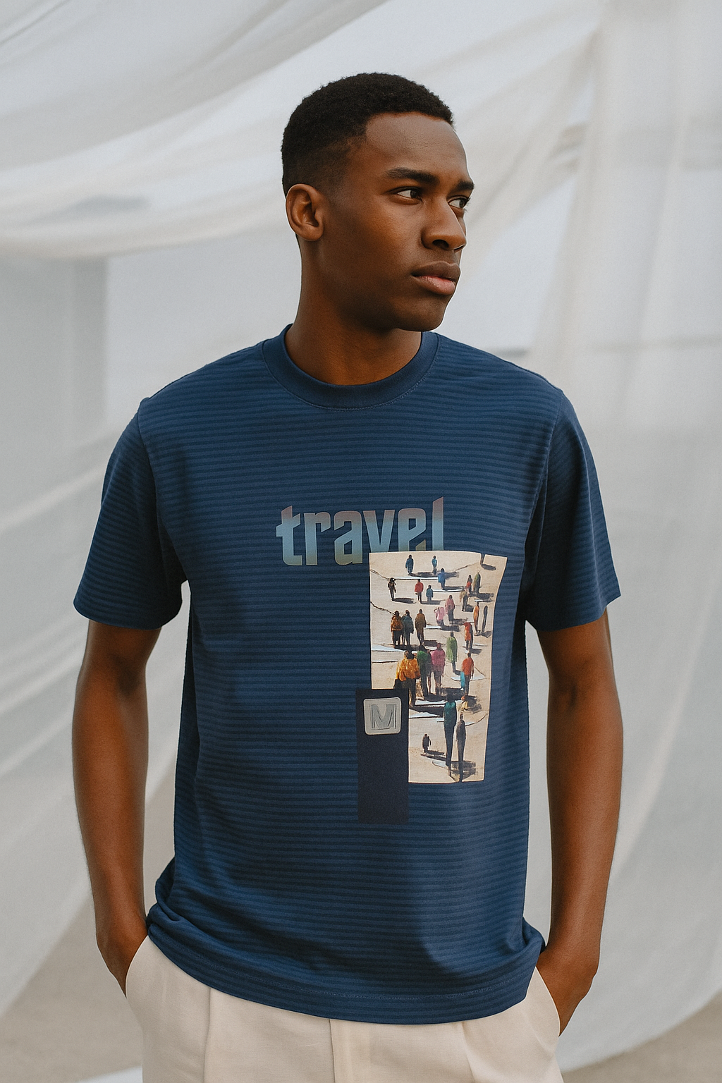 Man wearing a blue t-shirt with 'travel' and graphic design, standing against a white background