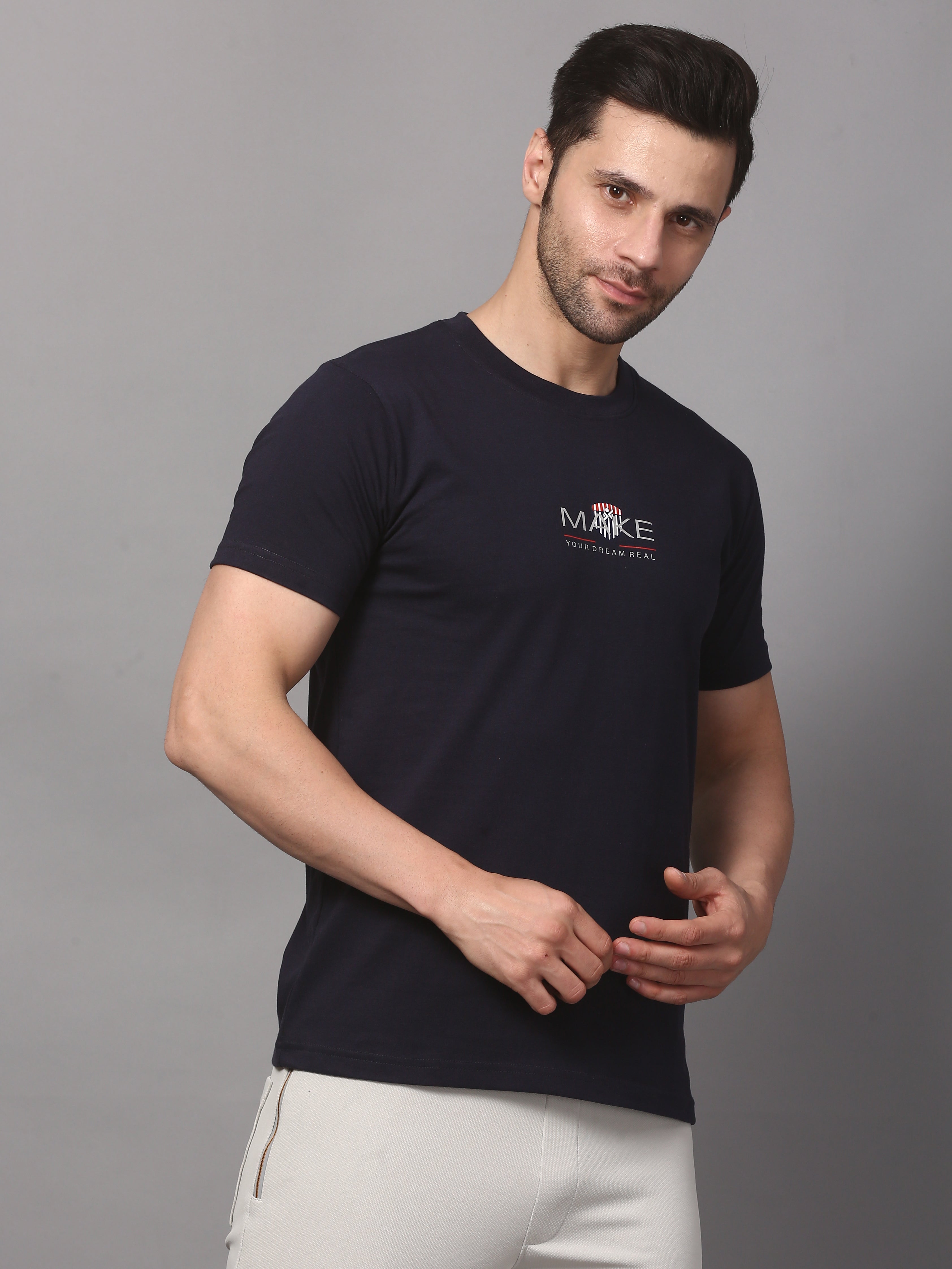 Man wearing a black t-shirt with a logo on a gray background