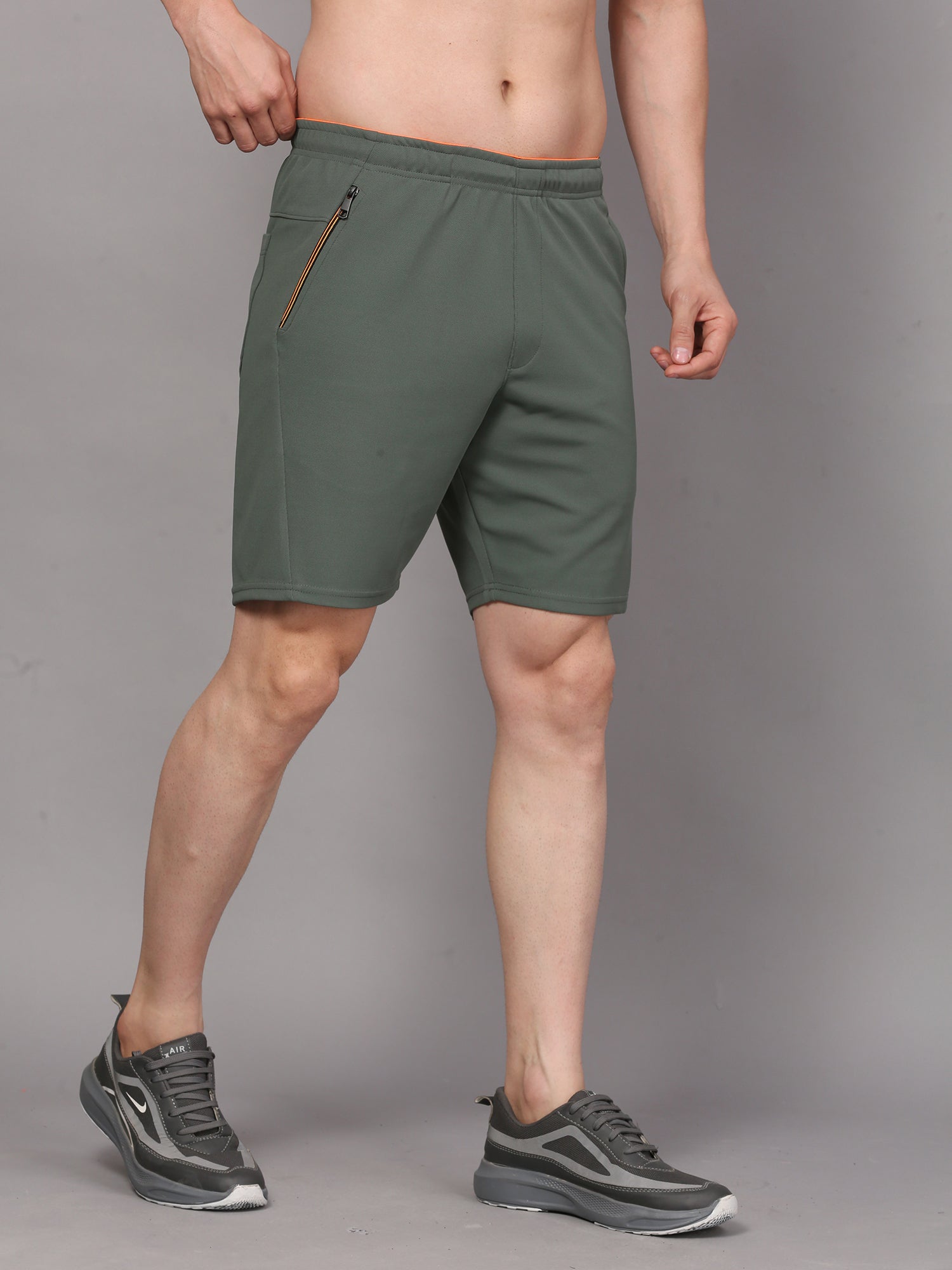 Person wearing green shorts with a zipper 