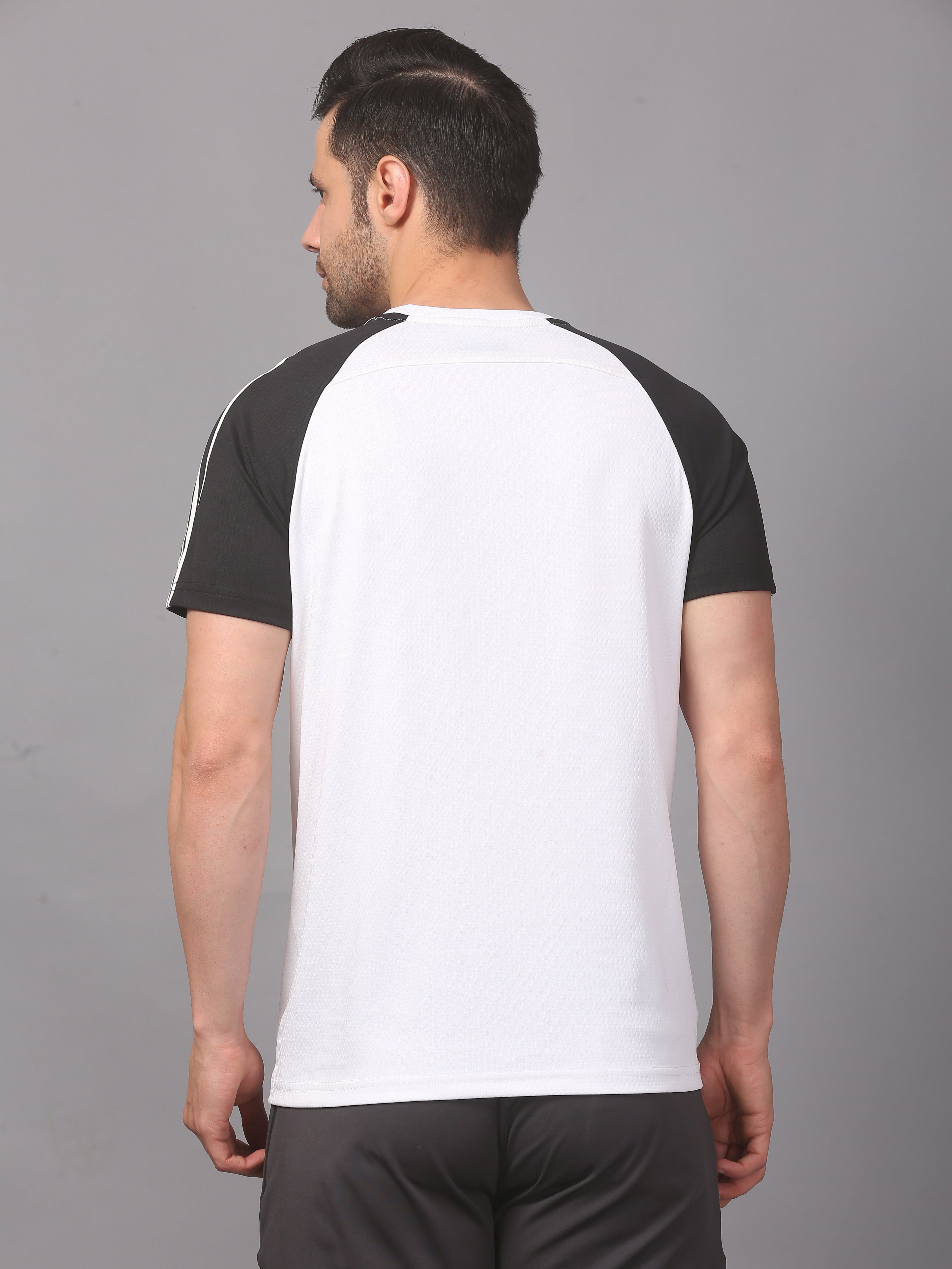 Man wearing a black and white baseball-style t-shirt on a gray background