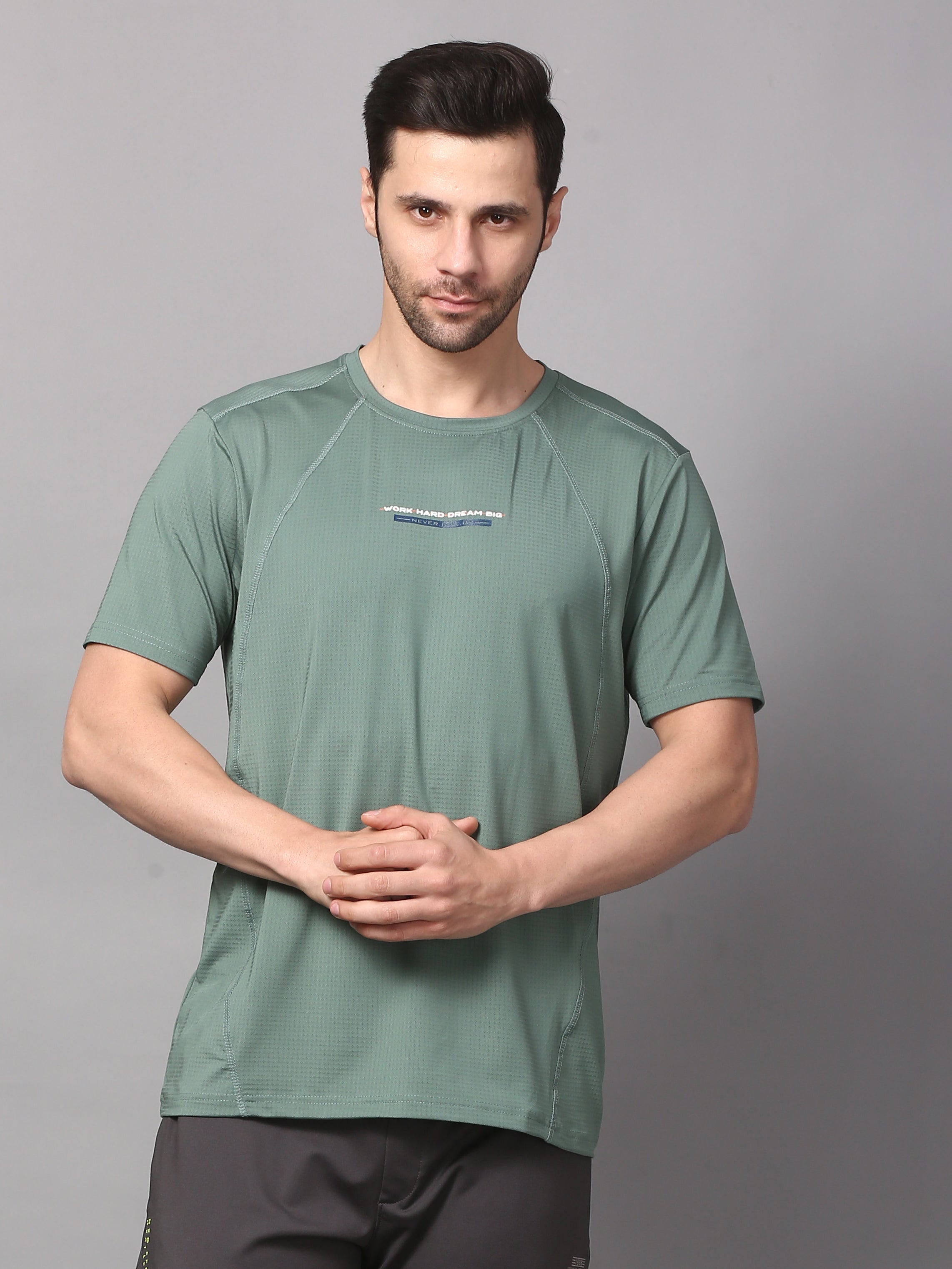 A man wearing a round neck sea green T-shirt.