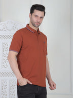 A rust brown polo shirt with pocket and piping details