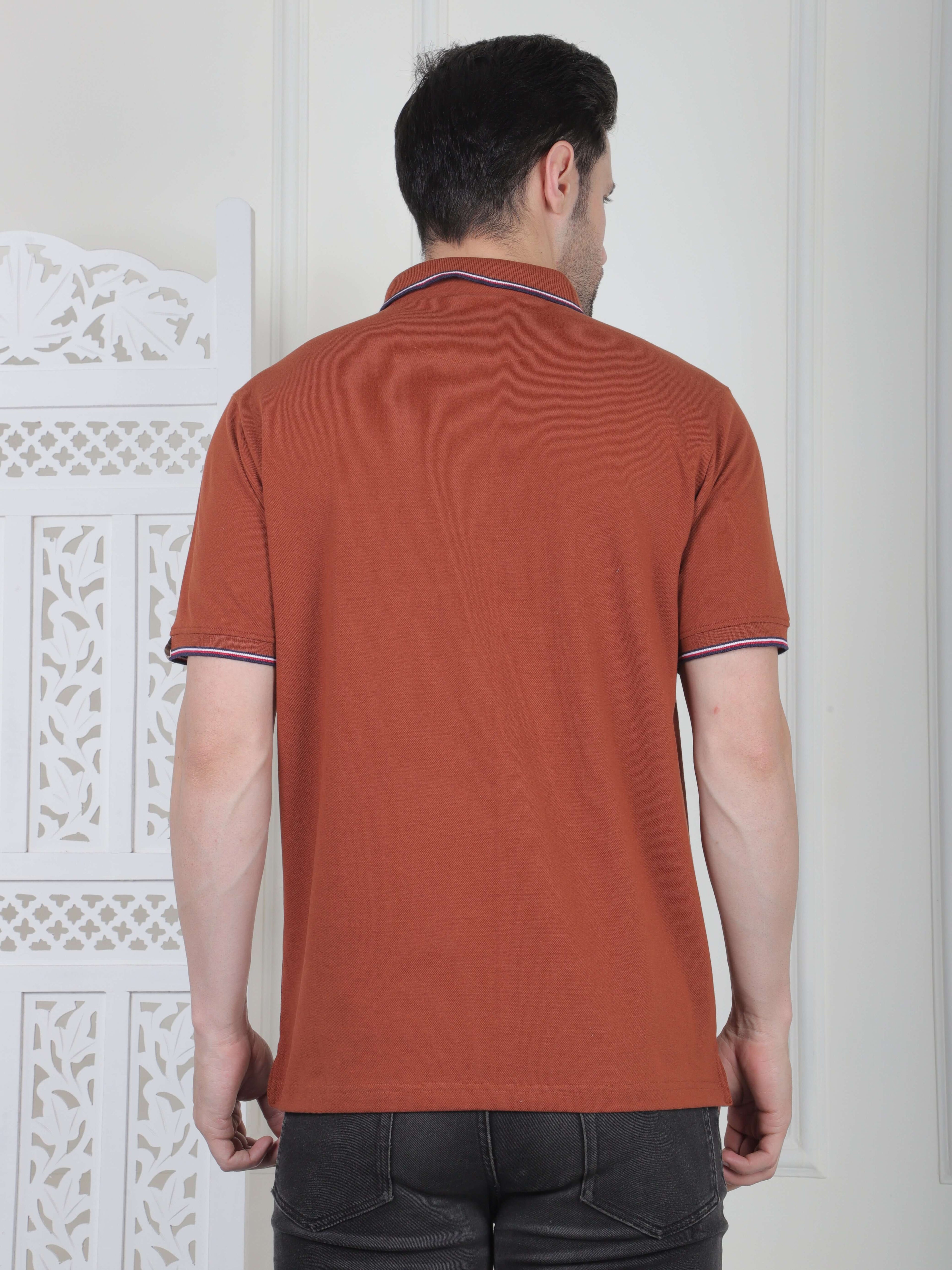A rust brown polo shirt with pocket and piping details