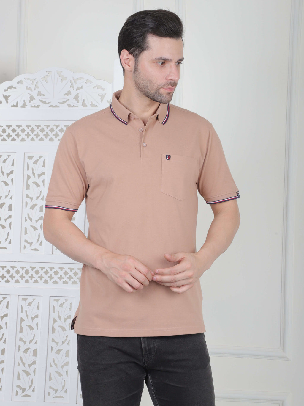 A rust beige polo shirt with pocket and piping details