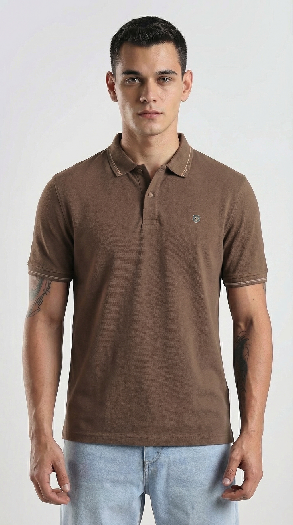 Man wearing a brown polo shirt with a small logo on a white background
